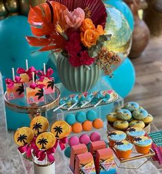 colorful desserts and cupcakes are displayed on a table