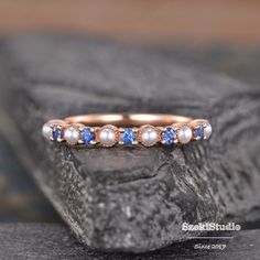 "Pearl Sapphire Wedding Band Women Rose Gold Pearl Matching Band Akoya Pearl Ring Half Eternity Stacking Minimalist Delicate Dainty Bridal Links in the same style: https://www.etsy.com/listing/1191477566/ https://www.etsy.com/listing/1394867395/ ITEM INFORMATION: Metal Type- Solid 14K White Gold *Wedding Band Details:  WIDTH-( approx. 2.0mm) Stone - Natural Akoya Pearl Size- 2mm Lab Sapphire, 1.5mm **Stone Replacement** Available with any other gemstones, please feel free to contact me for a quote. **Metal Type** Available in 14K or 18K yellow gold, white gold, and rose gold. Please select from the drop down menu. **Production Time& Rush Order** Our standard production time is 3-4 weeks from time of purchase. I am very happy to provide rush order service, the price is $60, the Process time Sapphire Pearl Engagement Ring, Adjustable Rose Gold Pearl Wedding Ring, Blue Minimalist Stackable Wedding Rings, Minimalist Blue Stackable Wedding Rings, Adjustable Half Eternity Stackable Rings For Wedding, Adjustable Rose Gold Stackable Rings For Wedding, Adjustable Pearl Wedding Ring, Adjustable Pearl Ring For Wedding, Sapphire And Pearl Ring