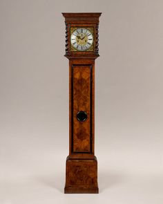 an old grandfather clock with roman numerals on the front and sides, standing upright against a gray background