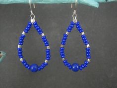 These beautiful earrings are comprised of sterling silver and blue glass beads. Measurements: 7/8 of an inch wide, 2 1/8 inches from the top of the earwire Weight: 3.2 grams Marks: 925 Earrings have been steam cleaned and sanitized. They are non returnable. Blue Drop Earrings With Dangling Beads, Blue Teardrop Hoop Earrings With Dangling Beads, Blue Teardrop Jewelry With Silver Beads, Blue Hoop Earrings With Dangling Beads Gift, Blue Dangle Earrings With Silver Beads, Adjustable Blue Beaded Earrings With Silver Beads, Nickel-free Blue Beaded Sterling Silver Earrings, Blue Dangling Beads Teardrop Earrings, Blue Silver Beads Drop Earrings