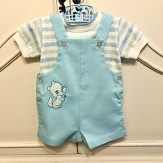 Adorable little Shortalls and shirt set. White shirt with light blue and mint green squares. 50/50 poly/cotton. 12" shoulder to hemline, 11" across.  Shortalls are light blue with an adorable squirrel appliqué patch on lower right side. Straps button at bib with snaps at stride. 17" shoulder to stride, 11" across.  Brand-Health-tex Size tag reads- 18 months This outfit is in amazingly wonderful condition with no visible flaws to note. Please view all images as they are part of the description. A Blue Shortalls For Spring Playtime, Fitted Cotton Bib Front Shortalls, Fitted Blue Cotton Shortalls, Baby Boy Clothing Sets, Cabbage Patch Kids, Patch Kids, Appliqué Patch, Boys Clothing, 50 50