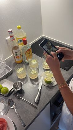 a woman sitting at a kitchen counter using her cell phone to take a selfie