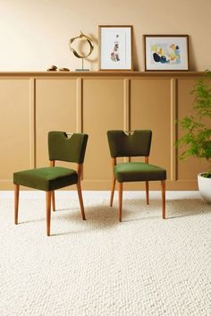 two green chairs sitting next to each other on top of a rug