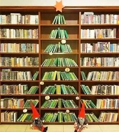 a christmas tree made out of books in front of a book shelf filled with lots of books