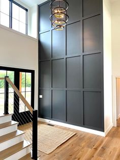 the interior of a house with stairs, windows and doors in black painted wood paneling