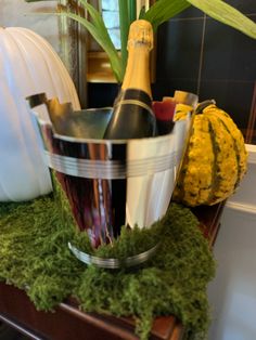 a wine bottle in a bucket on top of moss