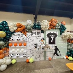 an indoor soccer themed event with balloons and t - shirts on display in the background