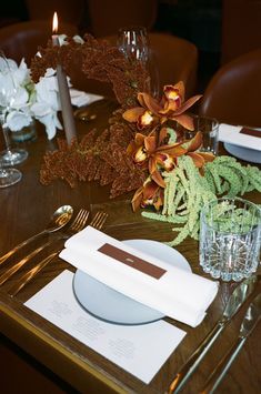 the table is set with silverware and flowers