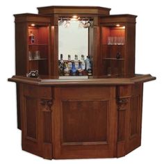 a wooden bar with wine glasses and bottles on it's counter top in front of a mirror