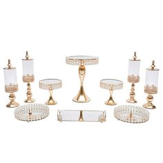 an assortment of glass and gold - plated candlesticks, cake plates, and trays