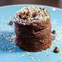 a chocolate cake with nuts and sprinkles on a blue plate