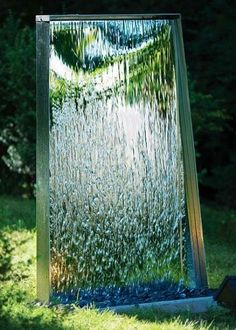 a water fountain in the middle of some grass