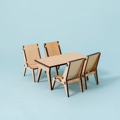 three chairs and a table made out of plywood with one chair facing the other