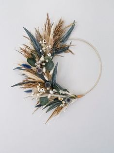 an arrangement of dried flowers and leaves on a white background