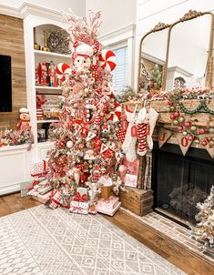 a christmas tree decorated with candy canes and ornaments in front of a fire place