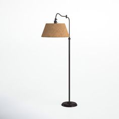 a floor lamp with a brown shade on it's side and a white background