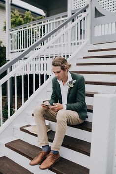 a man sitting on some steps looking at his cell phone