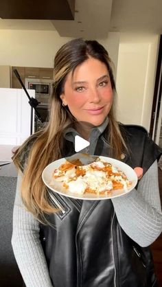 a woman holding a plate with food on it