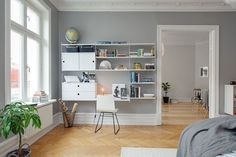 a bedroom with a desk, bookshelf and chair in it's corner