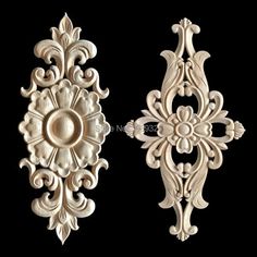 two decorative wall hangings made out of wood with an ornate design on the front and back