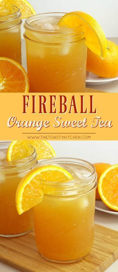 two jars filled with orange sweet tea sitting on top of a cutting board next to sliced oranges