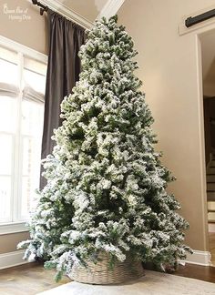 a white christmas tree sitting in front of a window