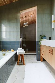 a bathroom with blue tile and wooden accents