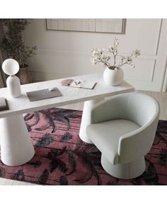 a white table topped with two chairs and a vase filled with flowers