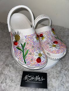 MyStyleMyWay's  custom crocs are designed for the perfect outfit, that special occasion, and "Just Because" you love blinged out crocs.  In the display shown we designed a pair of white classic crocs adding high quality colorful rhinestones. 🐞Each Rhinestone is individually and neatly placed to achieve the design.  🌼 Rhinestones are added to the top and buttom trimming of the shoe.  🐞 Personality Patch is applied to this design to add cuteness and personality.  🌼 Personalization on this design can be achieved upon request.  🐞 The sports mode strap is also designed.   🌼 When making your purchase - You're making a purchase for the exact style shown. If you would like a different color rhinestone,  and or different charms please message us so we can assist you. We're committed to the un Fun White Clogs For Spring, White Fun Spring Clogs, Blinged Out Crocs, Bedazzled Crocs, Daisy Patches, Classic Crocs, Custom Crocs, Bling Design, Bling Crafts