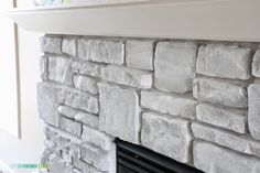 a stone fireplace with white paint on the mantle