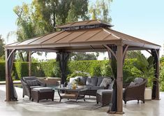 a gazebo sitting on top of a patio covered in furniture