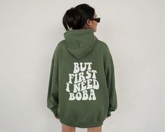 This trendy Boba Hoodie is the perfect addition to any boba lover's closet. Featuring "But First I Need Boba" in a retro font on the back, you'll be sure to turn heads while enjoying your favorite bubble tea. This unisex hoodie is plush, soft, and warm - a perfect choice for any cold day. In the front, the spacious kangaroo pocket adds daily practicality while the hood's drawstring is the same color as the base sweater for extra style points. All designs are available on t-shirts, sweatshirts, a Matcha Sweater, Matcha Shirt, Matcha Lover, Dragonfly Inn, Iced Matcha, Tea Lovers Gift, Stars Hollow, Retro Font, But First