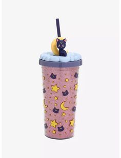 a cup with a cat sitting on top of it, next to a straw in the shape of a moon and stars