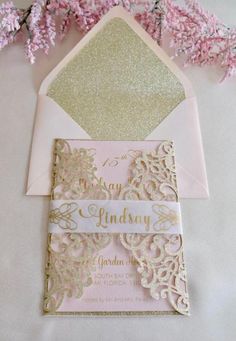 a pink and gold wedding card with an envelope