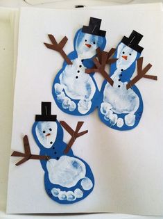 three snowmen made out of paper on a white surface