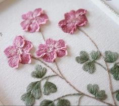 some pink flowers are on a white cloth