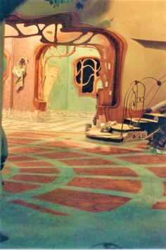 the interior of a house painted in pastel colors, with an arched doorway leading to another room