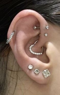 a woman with three different piercings on her ear and one is wearing an ear cuff