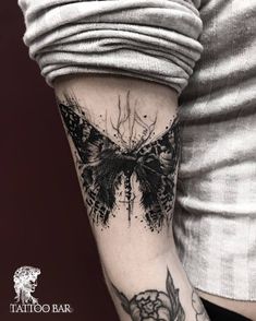 a woman's arm with a butterfly tattoo on it