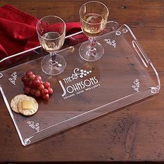 three wine glasses and some grapes on a tray