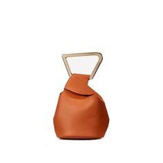 an orange leather bag with a metal handle on the front and side, sitting against a white background