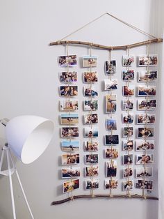 a white wall with pictures hanging on it and a lamp next to it in the corner