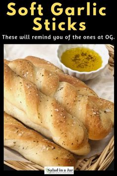 two loaves of bread sitting in a basket next to a bowl of olive oil