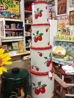 a large stack of ceramic containers with cherries painted on them in a room full of children's toys