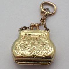 "Vintage 14k (.585) yellow gold locket charm or pendant in form of a lady's purse, decorated with engraved patterns. This charming piece is 1 1/8\" long, 1/2\" wide, weighing 2.6 grams. EA4944" Antique Charms Locket Necklace For Wedding, Heirloom Yellow Gold Locket Necklace With Charms, Antique Gold Locket Necklace With Charms, Elegant Compact Locket Jewelry, Gold Antique Locket Necklace With Charms, Antique Engraved Gold-tone Jewelry, Antique Yellow Gold Locket Necklace With Charms, Yellow Gold Locket Necklace With Vintage Charm For Collectors, Antique Gold-tone Engraved Jewelry