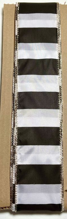 a piece of cardboard with black and white striped fabric on it's side, cut in half