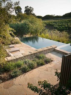 an outdoor swimming pool surrounded by greenery