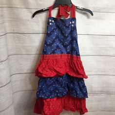 a red, white and blue dress hanging on a hanger next to a wall