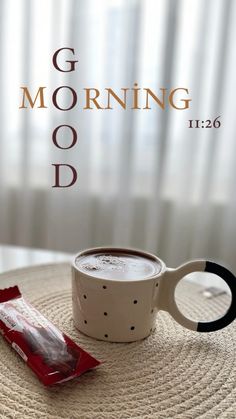 a cup of coffee sitting on top of a table next to a bag of food