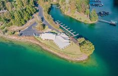 an aerial view of a house and dock in the middle of a body of water